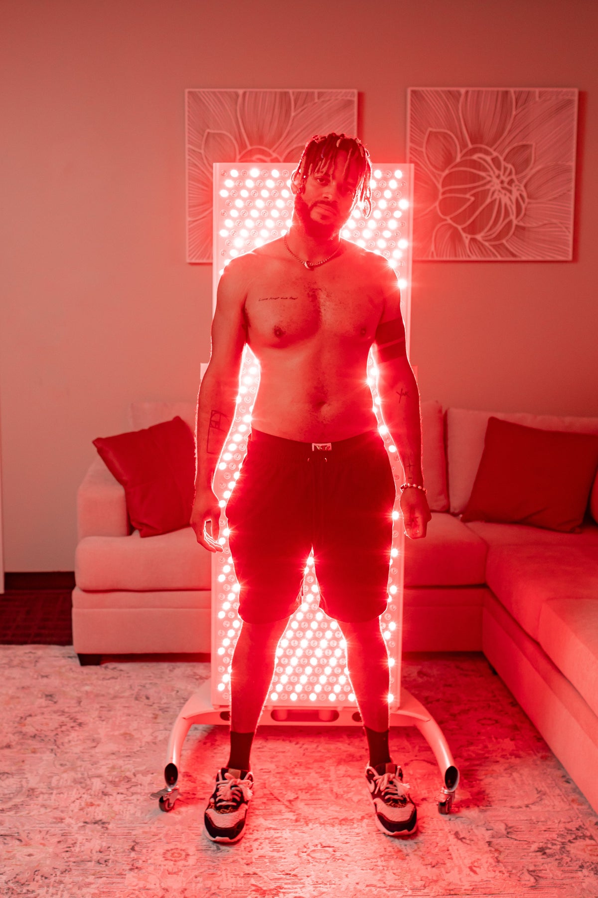 man standing facing away from commercial elite red light panel on rolling stand